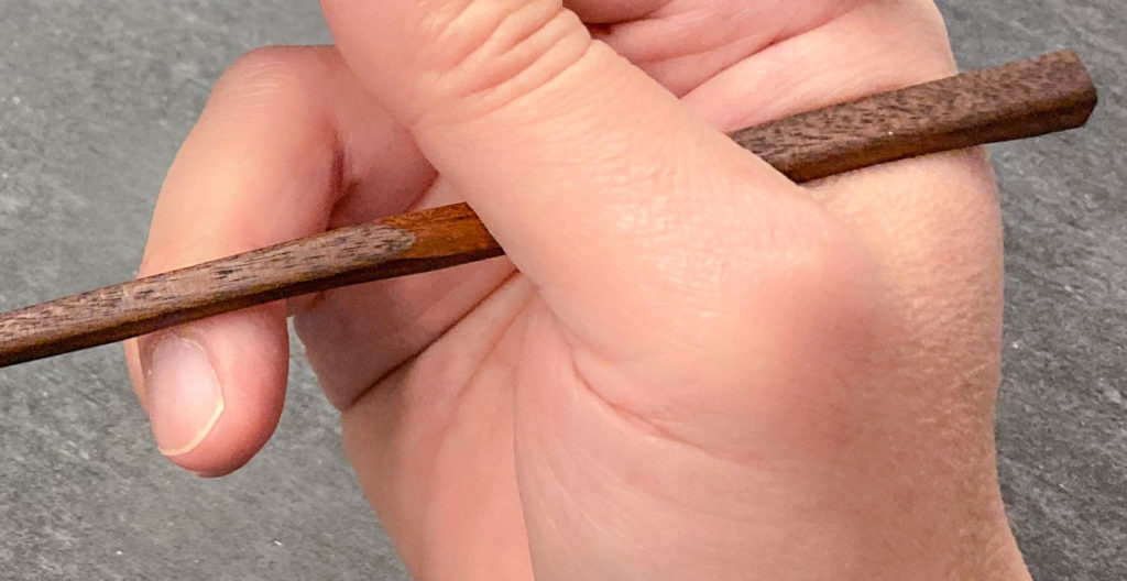 Finger placement chopsticks - Kobe Hashiya Ink Carved chopsticks - standard grip wide open posture - close-up of bottom stick